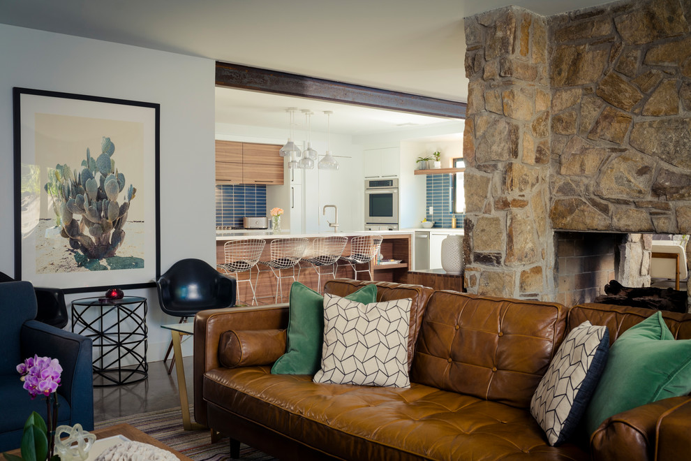 Источник вдохновения для домашнего уюта: изолированная гостиная комната среднего размера в стиле ретро с белыми стенами, бетонным полом, двусторонним камином, фасадом камина из камня и коричневым полом