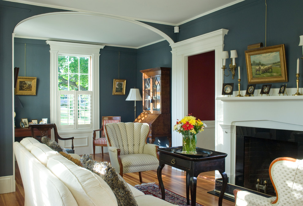 Example of a mid-sized country formal and enclosed light wood floor living room design in Boston with blue walls, a standard fireplace, a wood fireplace surround and no tv