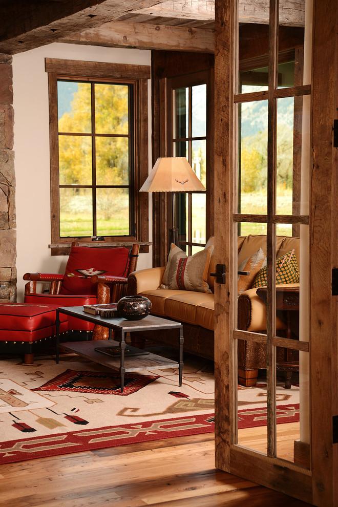 Idee per un soggiorno rustico di medie dimensioni e aperto con parquet scuro, camino classico, cornice del camino in pietra e tappeto