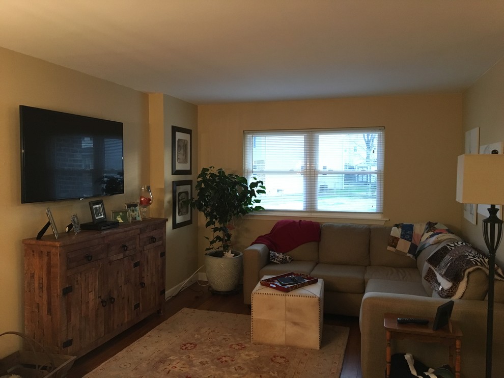 Foto di un piccolo soggiorno chic con pareti beige, pavimento in bambù e TV a parete