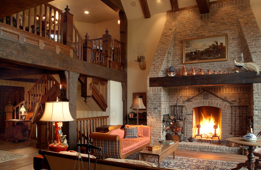Ejemplo de salón para visitas abierto rústico grande con paredes beige, suelo de madera en tonos medios, todas las chimeneas y marco de chimenea de ladrillo