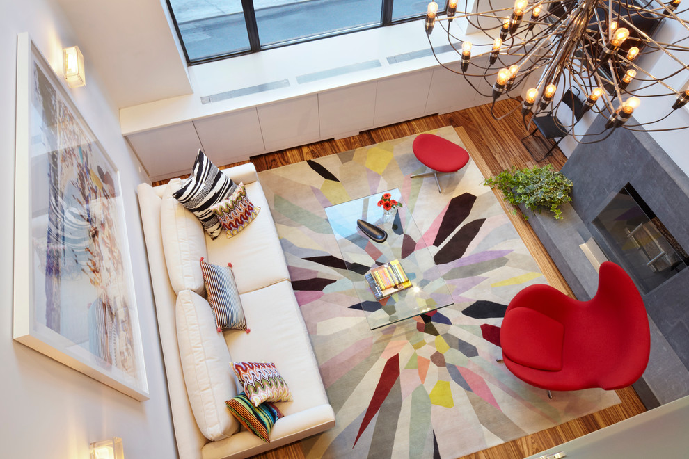 Inspiration for a small contemporary medium tone wood floor living room remodel in New York with white walls, a standard fireplace and a stone fireplace