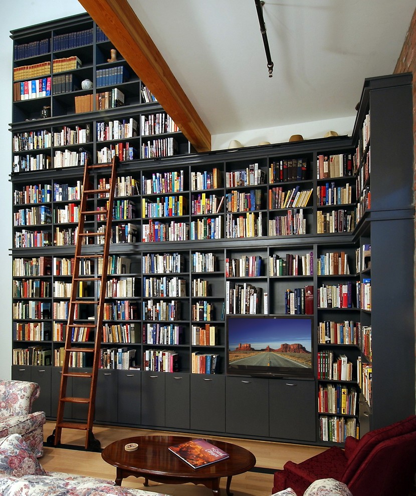 Foto di un grande soggiorno classico con libreria, pareti bianche, parquet chiaro, nessun camino e parete attrezzata