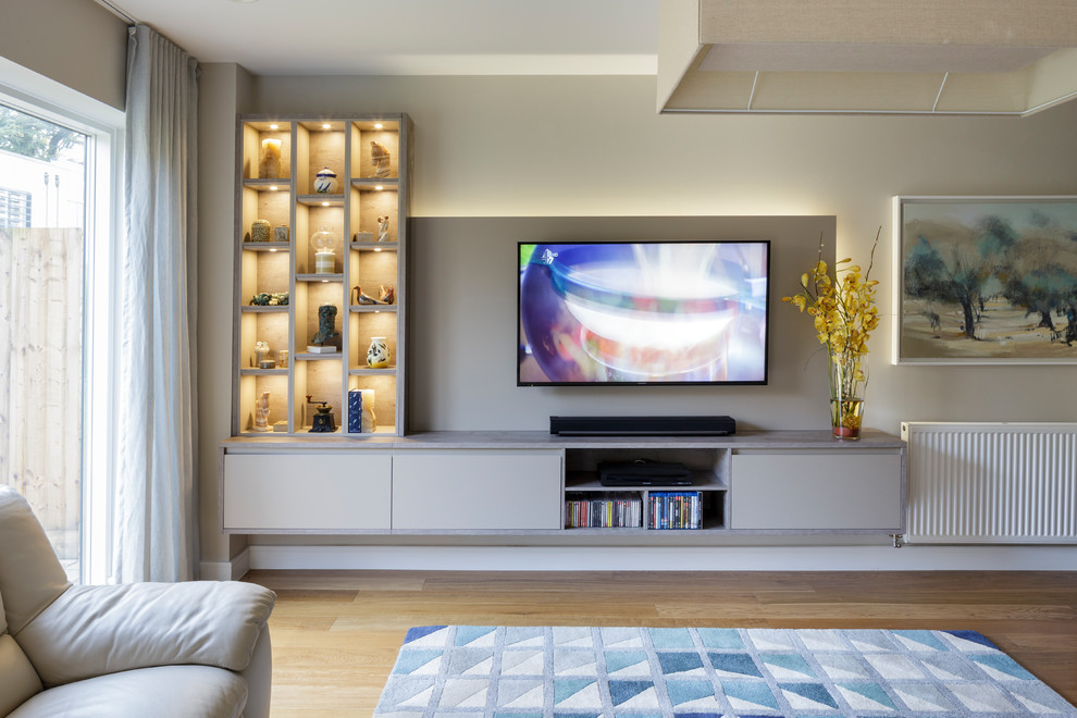 Ejemplo de salón contemporáneo con paredes grises y televisor colgado en la pared