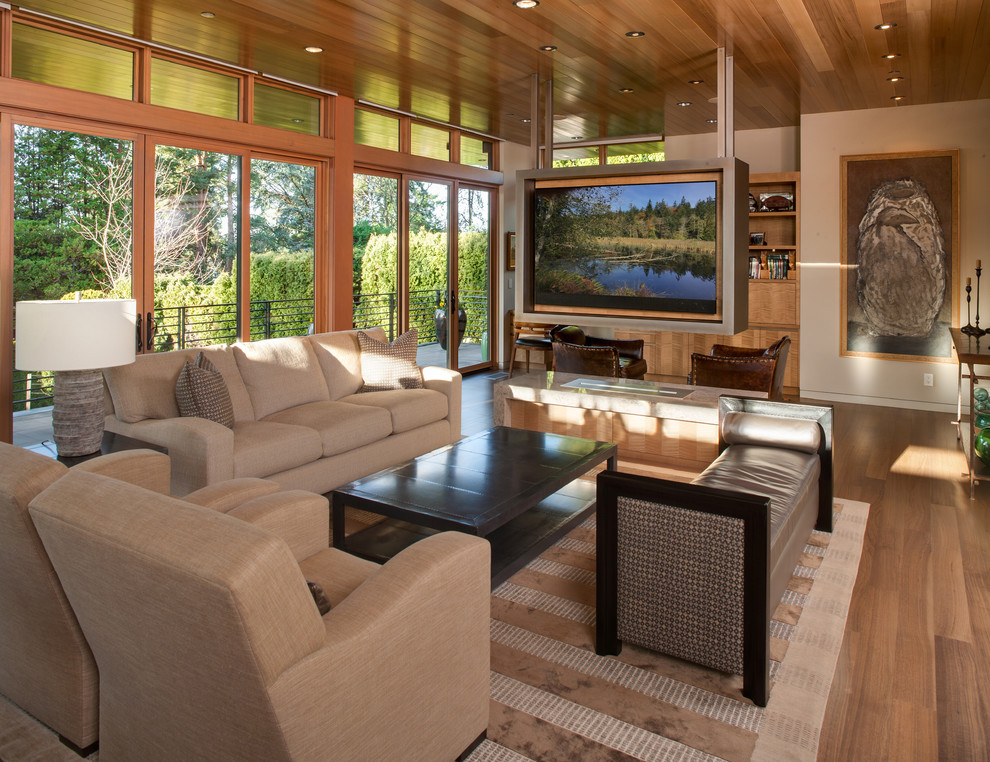 Cette image montre un salon design ouvert avec un mur beige, un sol en bois brun, une cheminée ribbon et un sol marron.