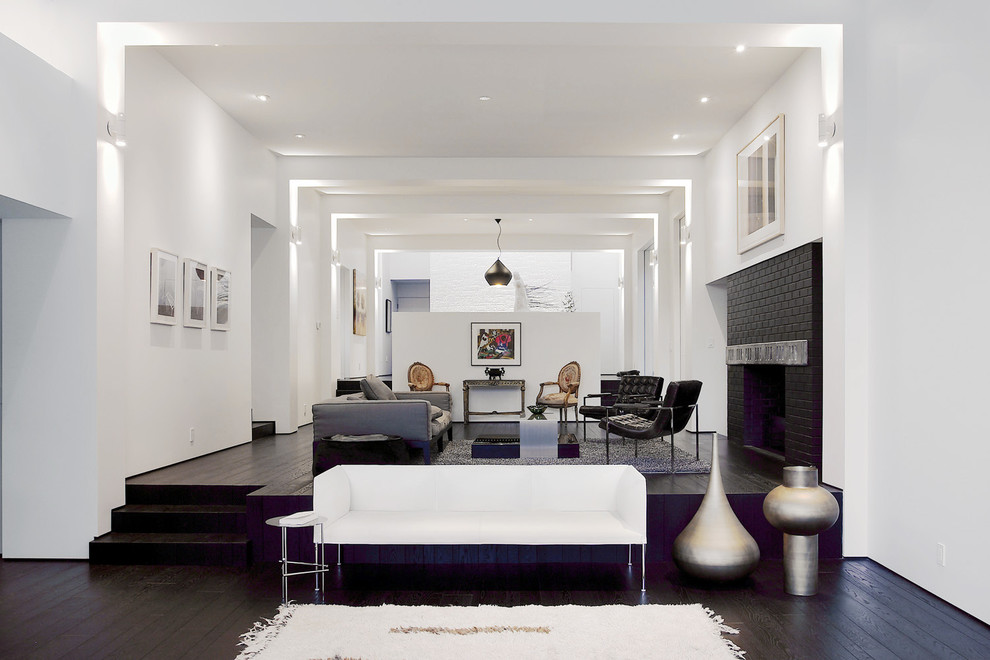 Foto di un soggiorno moderno con pareti bianche, parquet scuro, camino classico e cornice del camino in mattoni