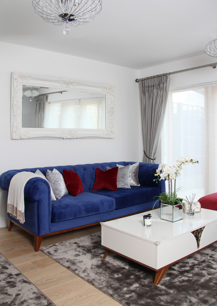 На фото: изолированная гостиная комната среднего размера в средиземноморском стиле с белыми стенами и телевизором на стене с