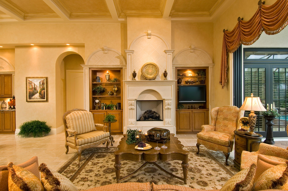 Cette photo montre un grand salon chic ouvert avec un mur beige, un sol en travertin, une cheminée standard, un téléviseur indépendant et un sol beige.