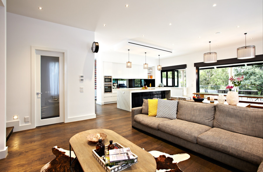 Idée de décoration pour un grand salon design ouvert avec un mur blanc, parquet foncé et un sol marron.