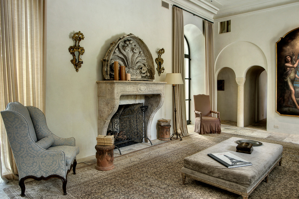 This is an example of a mediterranean living room in Houston with beige walls, a standard fireplace and a stone fireplace surround.