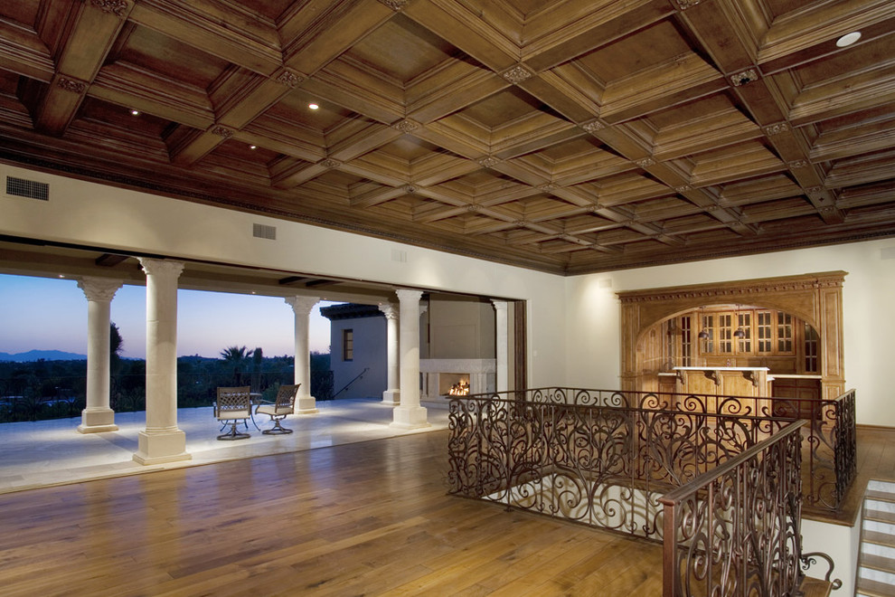 Imagen de salón mediterráneo con suelo de madera oscura y arcos