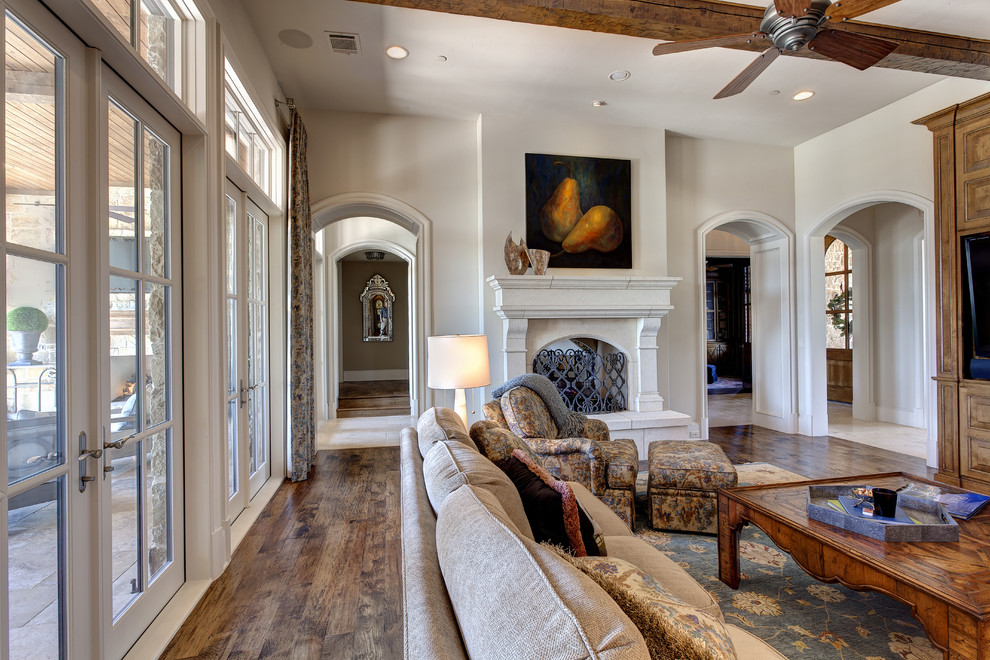 Inspiration for a mediterranean formal and enclosed dark wood floor living room remodel in Dallas with white walls, a standard fireplace and a media wall
