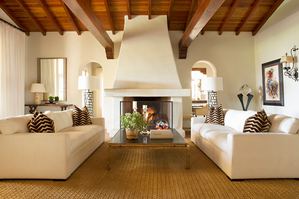 Imagen de salón mediterráneo con paredes beige, suelo de madera oscura y todas las chimeneas