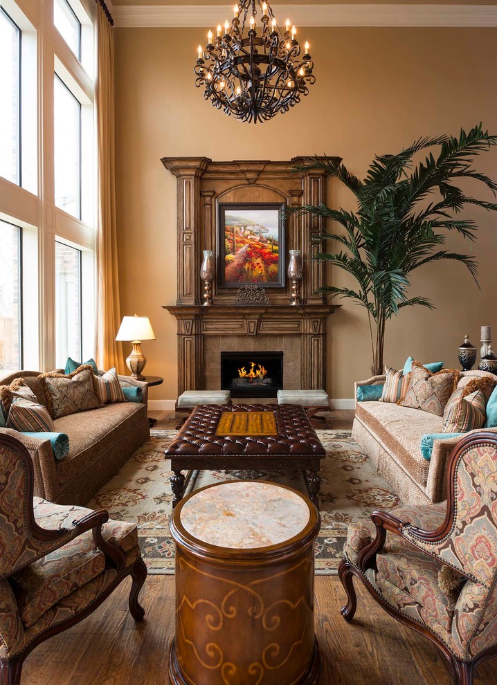 Example of a large tuscan formal and open concept medium tone wood floor living room design in Other with beige walls, a standard fireplace and a wood fireplace surround
