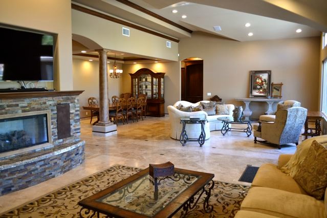 Living room - huge traditional open concept and formal travertine floor living room idea in Orange County with a wall-mounted tv, brown walls, a standard fireplace and a stone fireplace