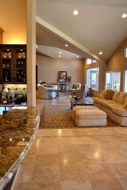 Design ideas for an expansive classic formal open plan living room in Orange County with a wall mounted tv, brown walls, travertine flooring, a standard fireplace and a stone fireplace surround.