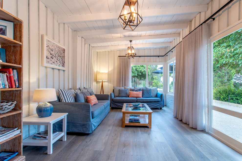 На фото: гостиная комната в морском стиле с белыми стенами, светлым паркетным полом и бежевым полом с