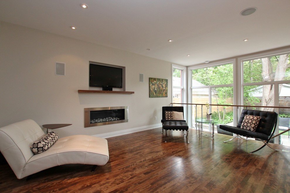 Example of a mid-sized trendy open concept medium tone wood floor and brown floor living room design in Ottawa with a wall-mounted tv, beige walls, a ribbon fireplace and a metal fireplace