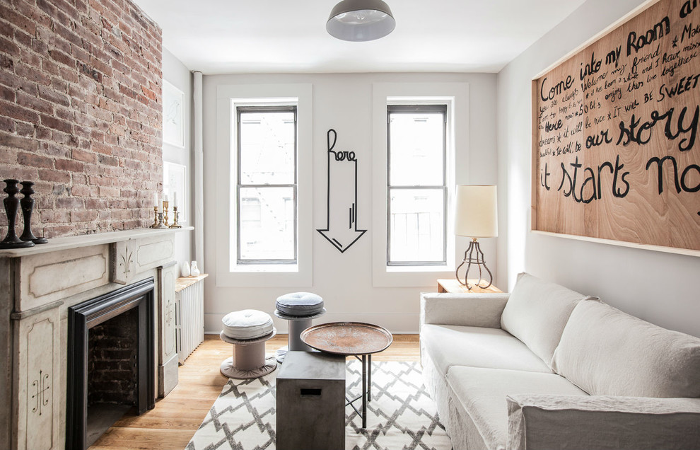 Kleines, Fernseherloses, Abgetrenntes Stilmix Wohnzimmer mit grauer Wandfarbe, braunem Holzboden und Kamin in New York