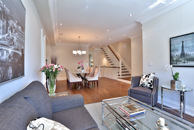 Example of a large transitional formal and open concept medium tone wood floor living room design in Toronto with beige walls, no fireplace and no tv