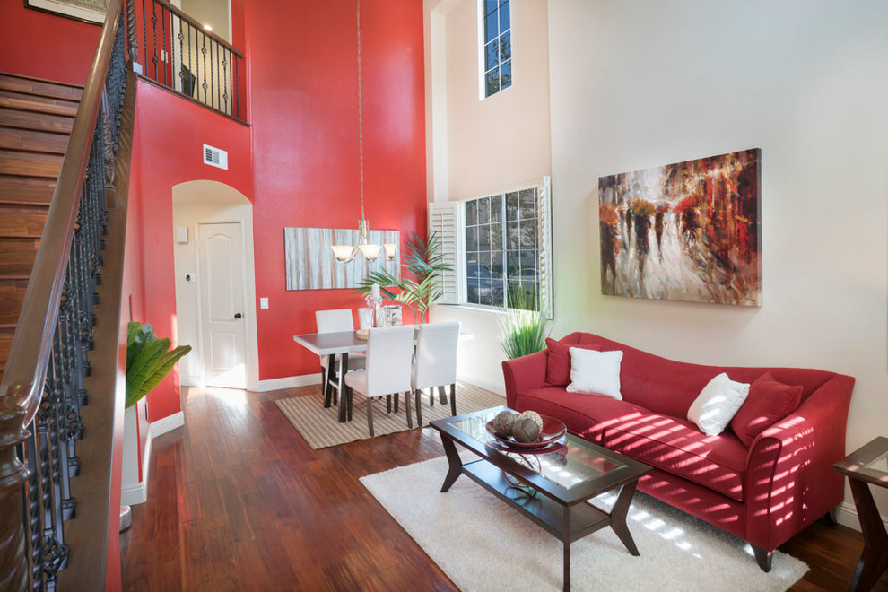 Идея дизайна: большая открытая гостиная комната в стиле неоклассика (современная классика) с красными стенами, паркетным полом среднего тона и коричневым полом без камина, телевизора
