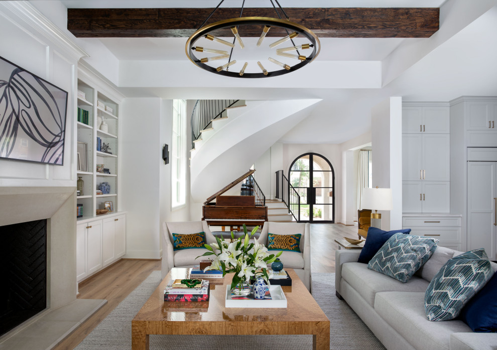 Inspiration for an expansive contemporary open plan living room in Houston with white walls, light hardwood flooring, a standard fireplace, a stone fireplace surround, a wall mounted tv, exposed beams and panelled walls.
