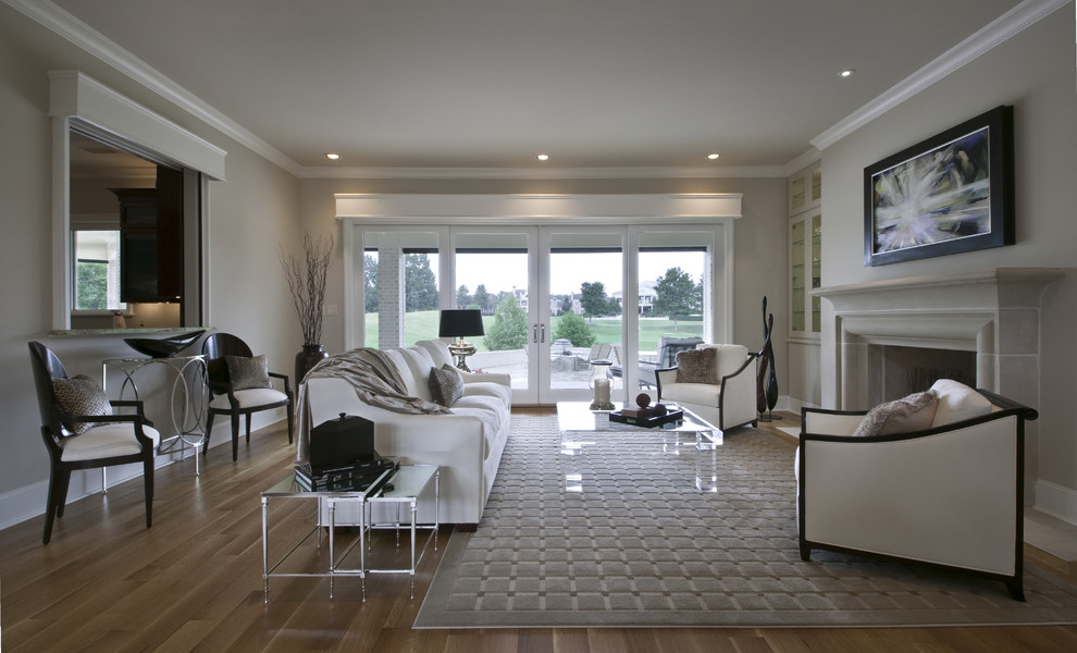Idee per un soggiorno contemporaneo con pareti beige, pavimento in legno massello medio, camino classico, cornice del camino in pietra e tappeto