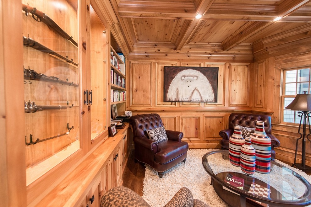 Foto di un soggiorno tradizionale di medie dimensioni e chiuso con libreria, pavimento in legno massello medio, cornice del camino in legno e nessuna TV