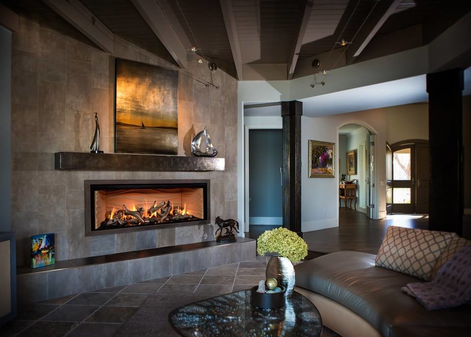 Aménagement d'un salon moderne ouvert avec un sol en ardoise, une cheminée standard, un manteau de cheminée en carrelage et un sol marron.