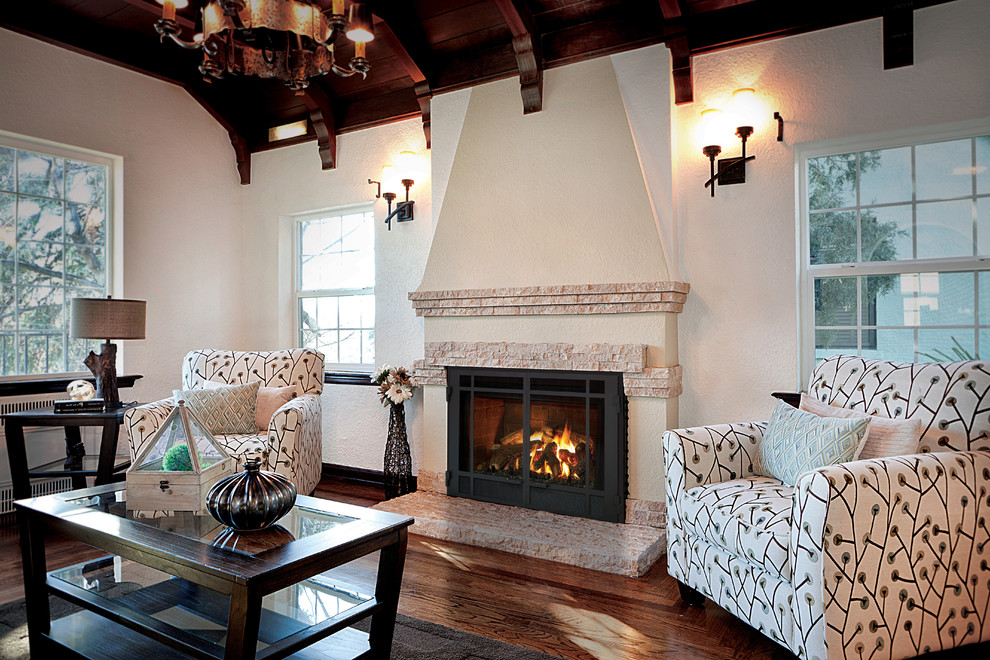 This is an example of a medium sized open plan living room in Baltimore with white walls, dark hardwood flooring, a standard fireplace, a plastered fireplace surround and brown floors.