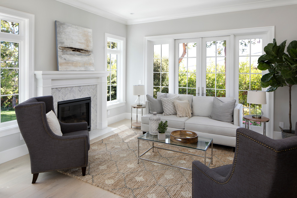 Example of a large transitional formal and open concept light wood floor and brown floor living room design in San Francisco with gray walls, a standard fireplace, a stone fireplace and no tv