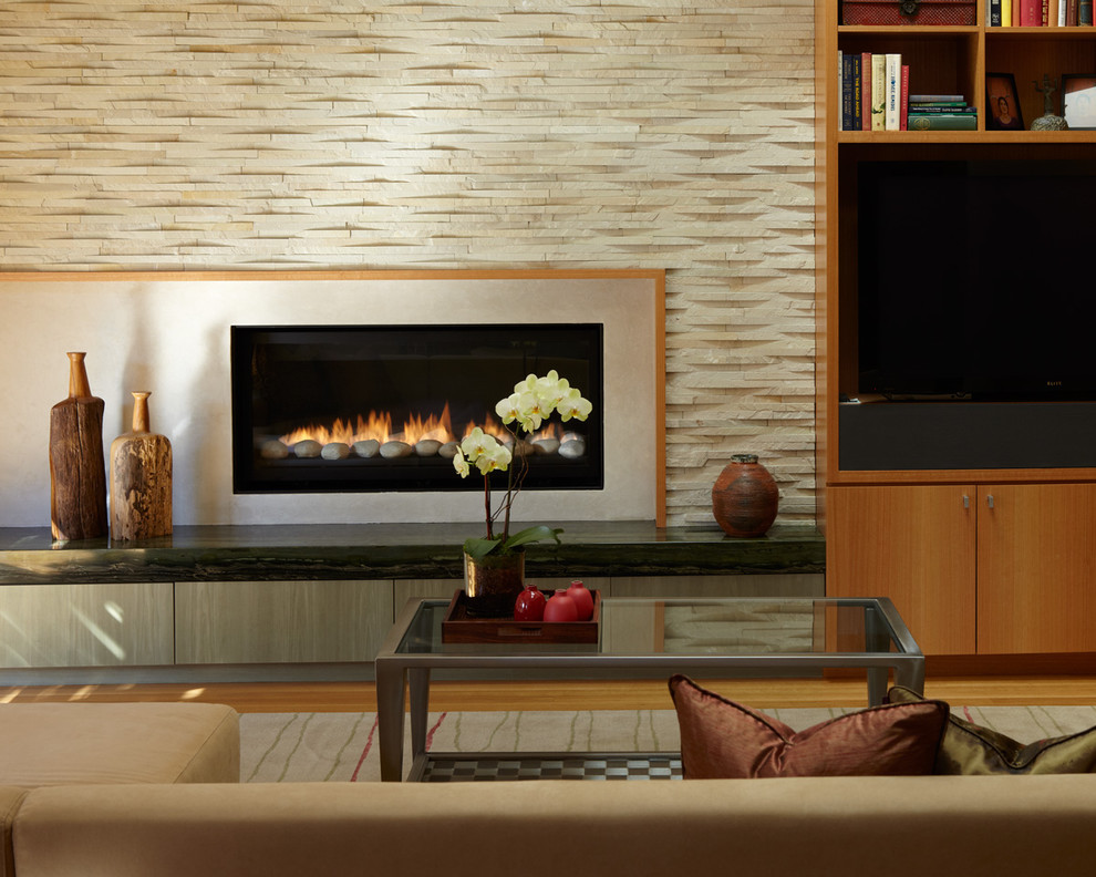 Mid-sized trendy open concept light wood floor and brown floor living room library photo in San Francisco with beige walls, a standard fireplace, a concrete fireplace and a media wall