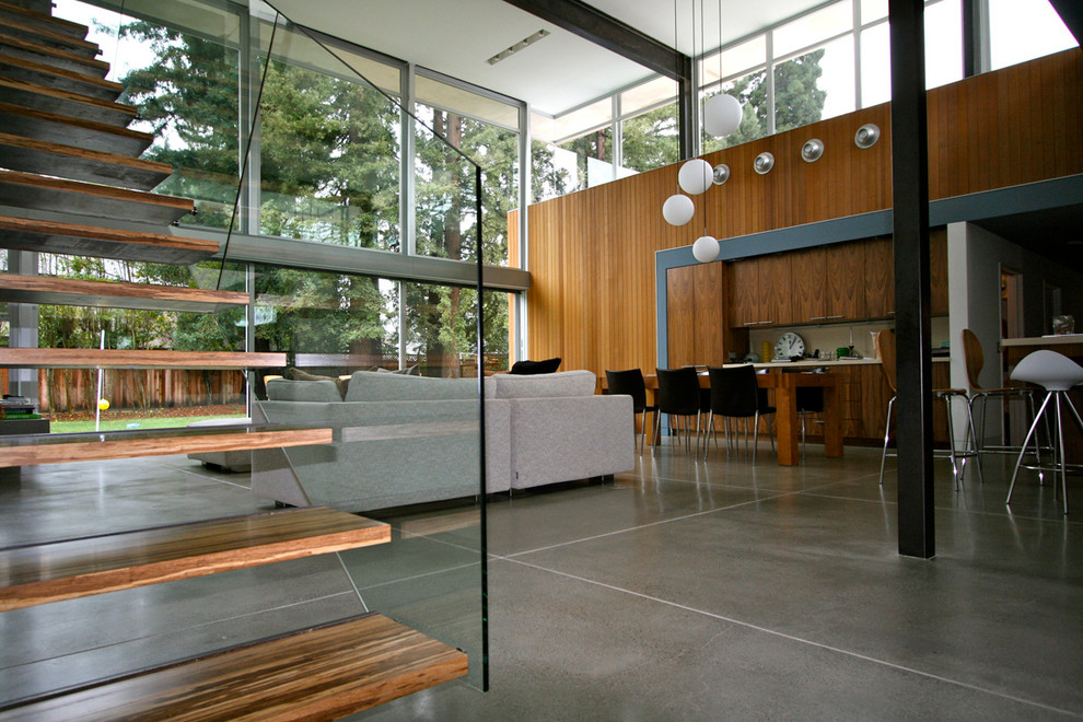 Foto på ett stort funkis loftrum, med betonggolv, en standard öppen spis, en spiselkrans i betong och en väggmonterad TV