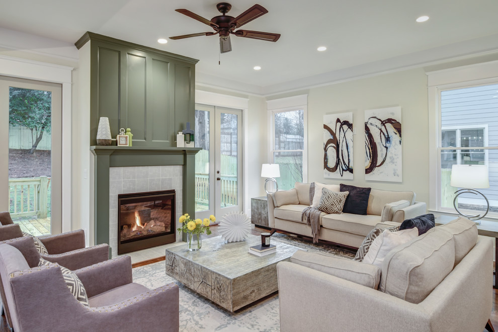 Klassisches Wohnzimmer mit beiger Wandfarbe, braunem Holzboden, Kamin, gefliester Kaminumrandung und braunem Boden in Atlanta