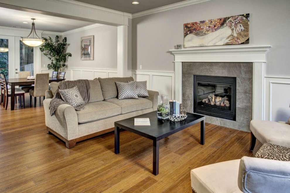 Example of a mid-sized classic formal and open concept bamboo floor and brown floor living room design in Seattle with beige walls, a standard fireplace and a tile fireplace