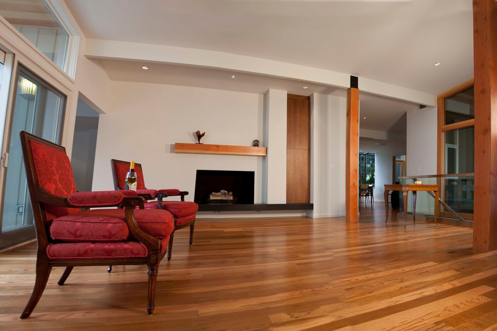 Esempio di un soggiorno minimal aperto con pavimento in legno massello medio