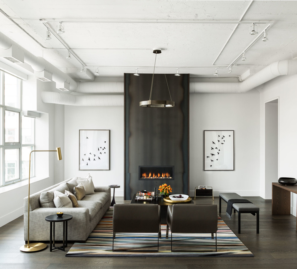 Inspiration for a large traditional formal enclosed living room in Toronto with white walls, dark hardwood flooring, a ribbon fireplace, a metal fireplace surround, no tv, brown floors and feature lighting.