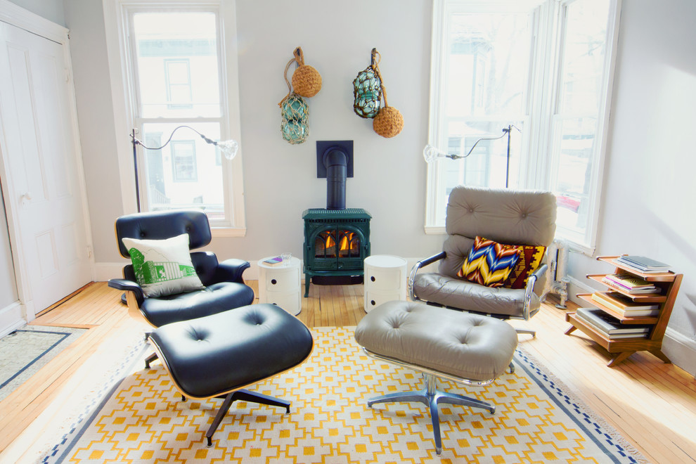 Eclectic formal enclosed living room in Portland Maine with a wood burning stove.