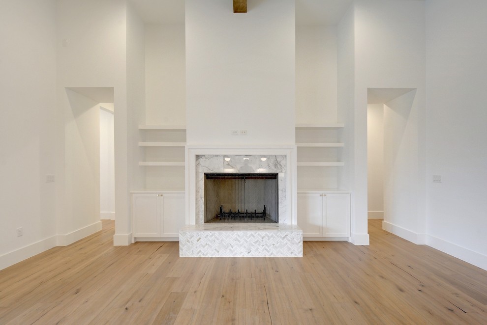 Großes, Offenes Modernes Wohnzimmer mit weißer Wandfarbe, hellem Holzboden, Kamin, Kaminumrandung aus Stein und TV-Wand in Austin