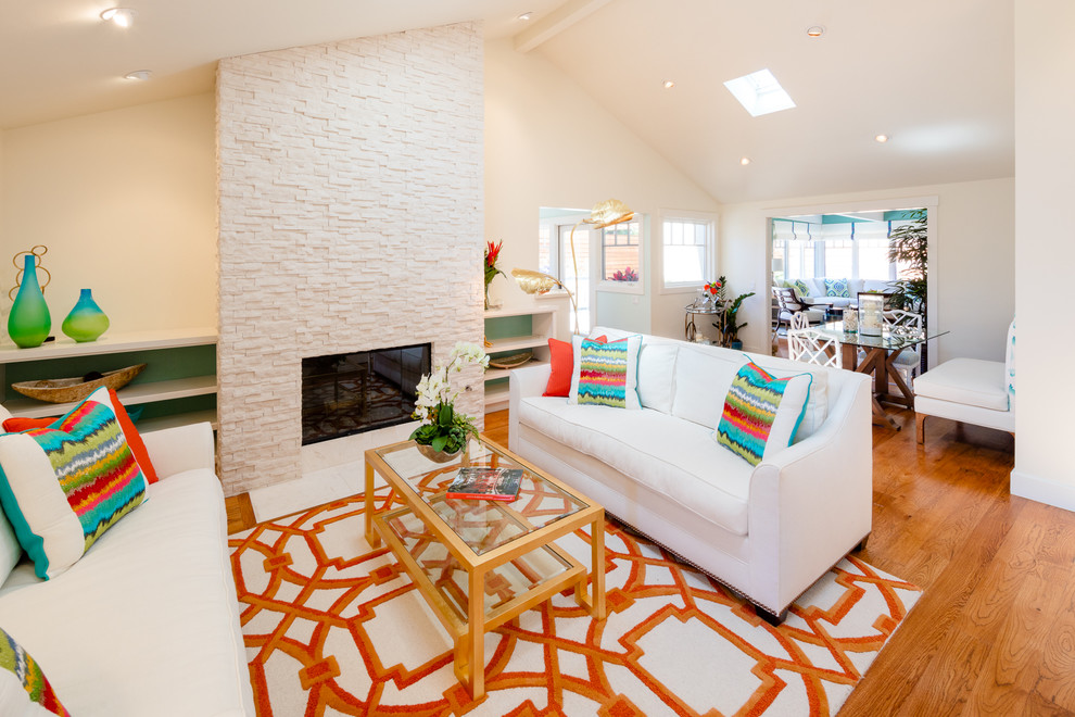 This is an example of a medium sized beach style open plan living room in Santa Barbara with a standard fireplace and a stone fireplace surround.