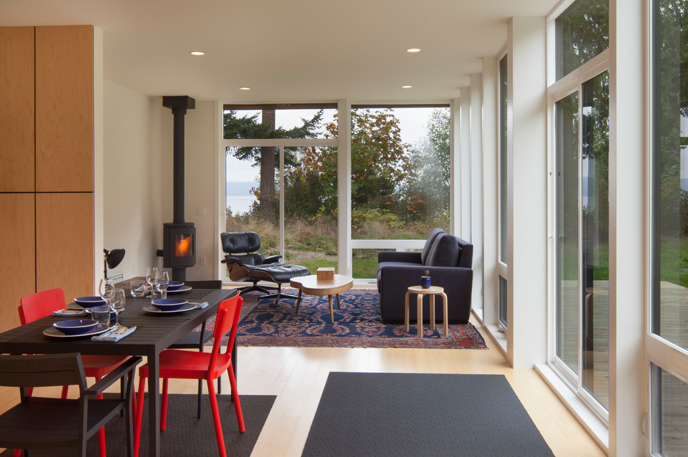Esempio di un soggiorno moderno con parquet chiaro e stufa a legna