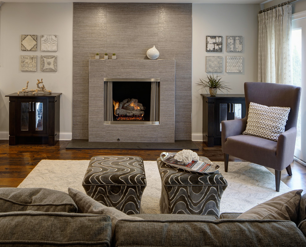 Источник вдохновения для домашнего уюта: открытая гостиная комната среднего размера в стиле неоклассика (современная классика) с серыми стенами, темным паркетным полом, стандартным камином и фасадом камина из плитки