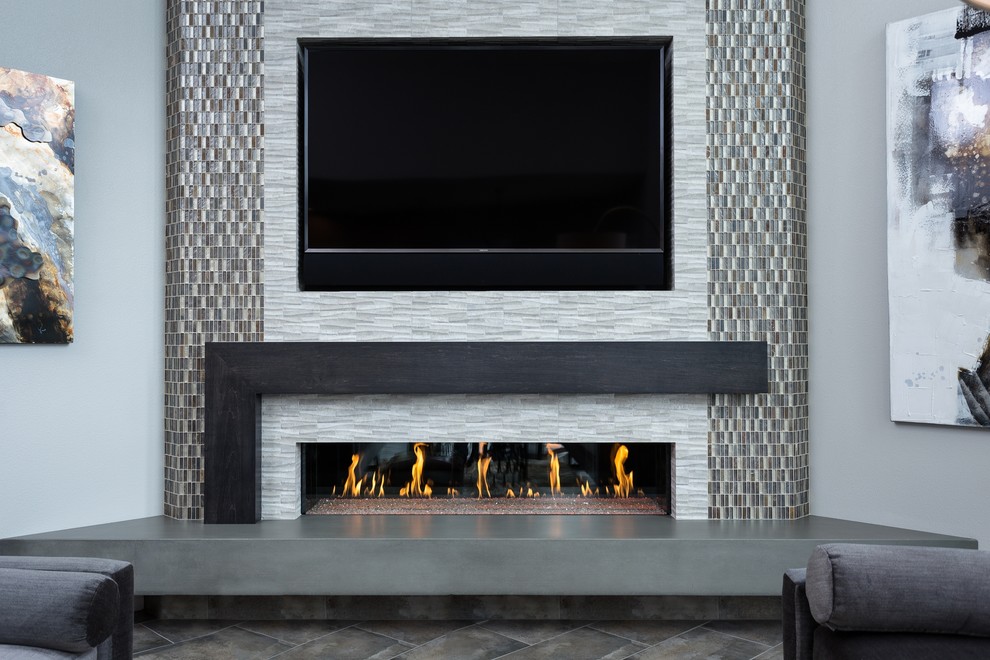 ポートランドにあるミッドセンチュリースタイルのおしゃれなLDK (グレーの壁、セラミックタイルの床、横長型暖炉、タイルの暖炉まわり、壁掛け型テレビ) の写真