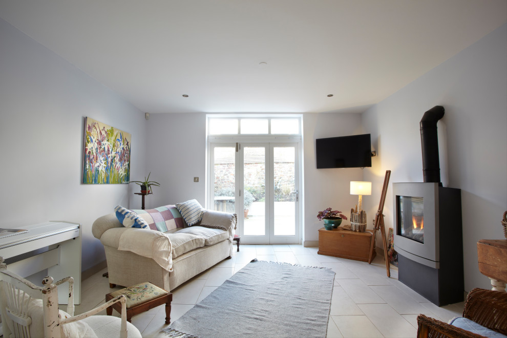 Mittelgroßes, Abgetrenntes Stilmix Wohnzimmer mit blauer Wandfarbe, TV-Wand, beigem Boden und Keramikboden in Sussex