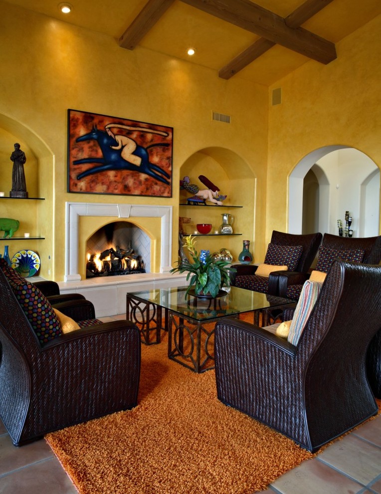 На фото: открытая гостиная комната в стиле фьюжн с желтыми стенами, полом из терракотовой плитки, стандартным камином и фасадом камина из плитки