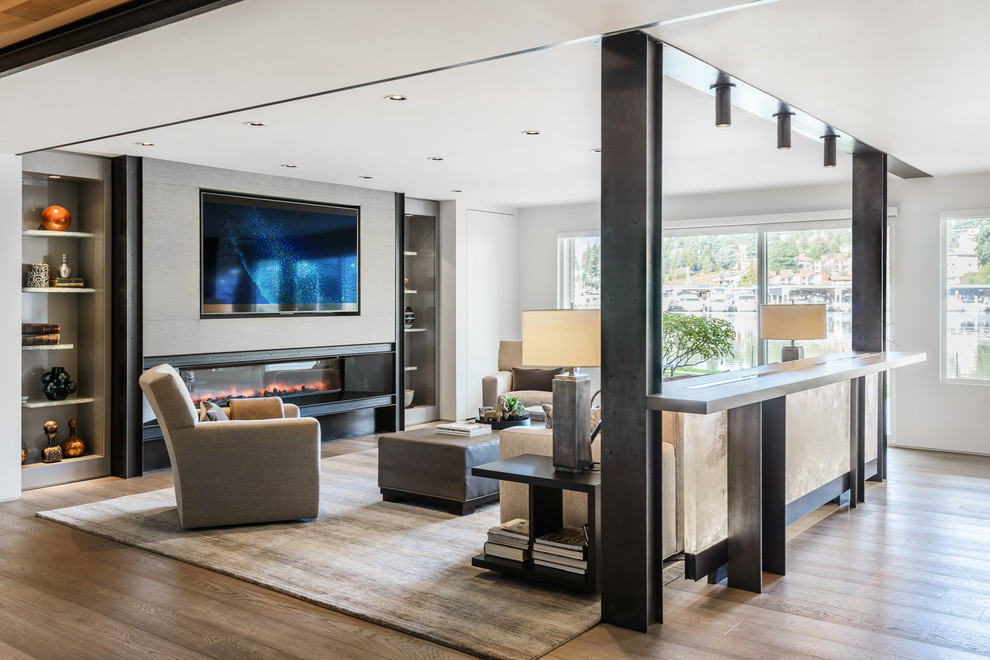 Inspiration for a medium sized contemporary open plan living room in Seattle with a metal fireplace surround, a wall mounted tv, white walls, medium hardwood flooring, a ribbon fireplace and brown floors.