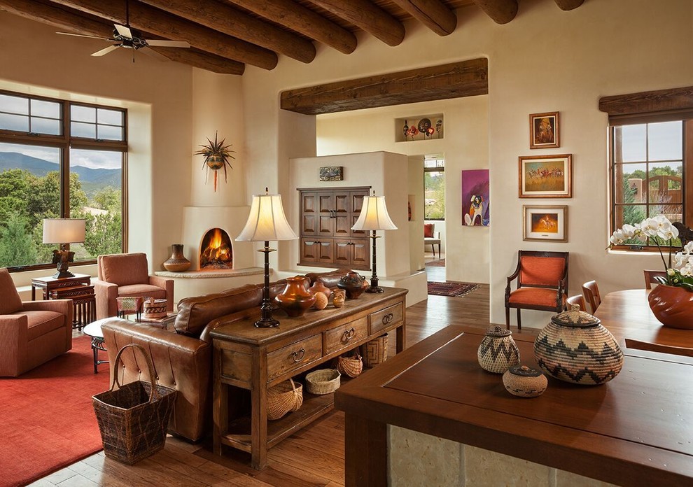 Inspiration pour un grand salon traditionnel avec un mur beige, un sol en bois brun, une cheminée d'angle et un manteau de cheminée en plâtre.