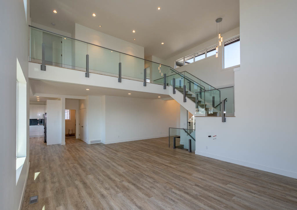 Exempel på ett stort modernt loftrum, med vita väggar, vinylgolv, en hängande öppen spis, en väggmonterad TV och beiget golv