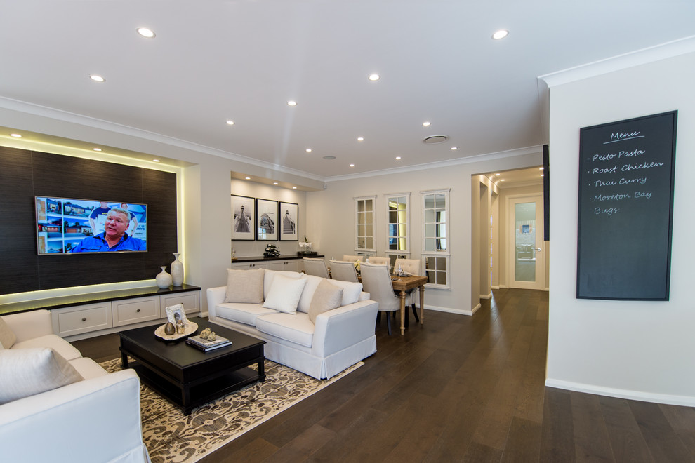 На фото: огромная открытая гостиная комната в современном стиле с телевизором на стене без камина с