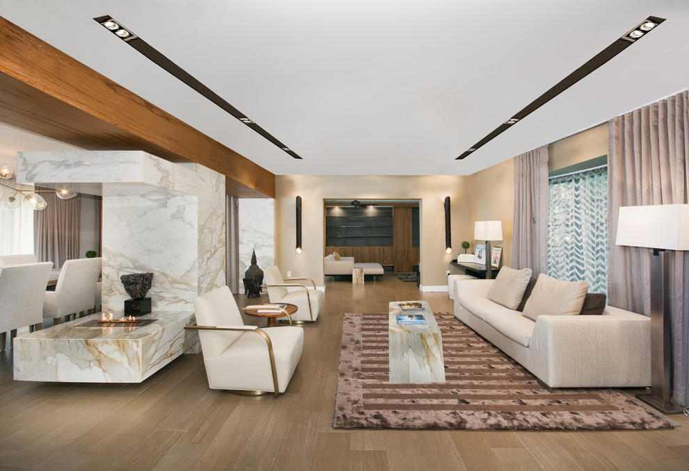 Inspiration for a large contemporary formal and open concept light wood floor living room remodel in Miami with beige walls, a two-sided fireplace, a stone fireplace and no tv